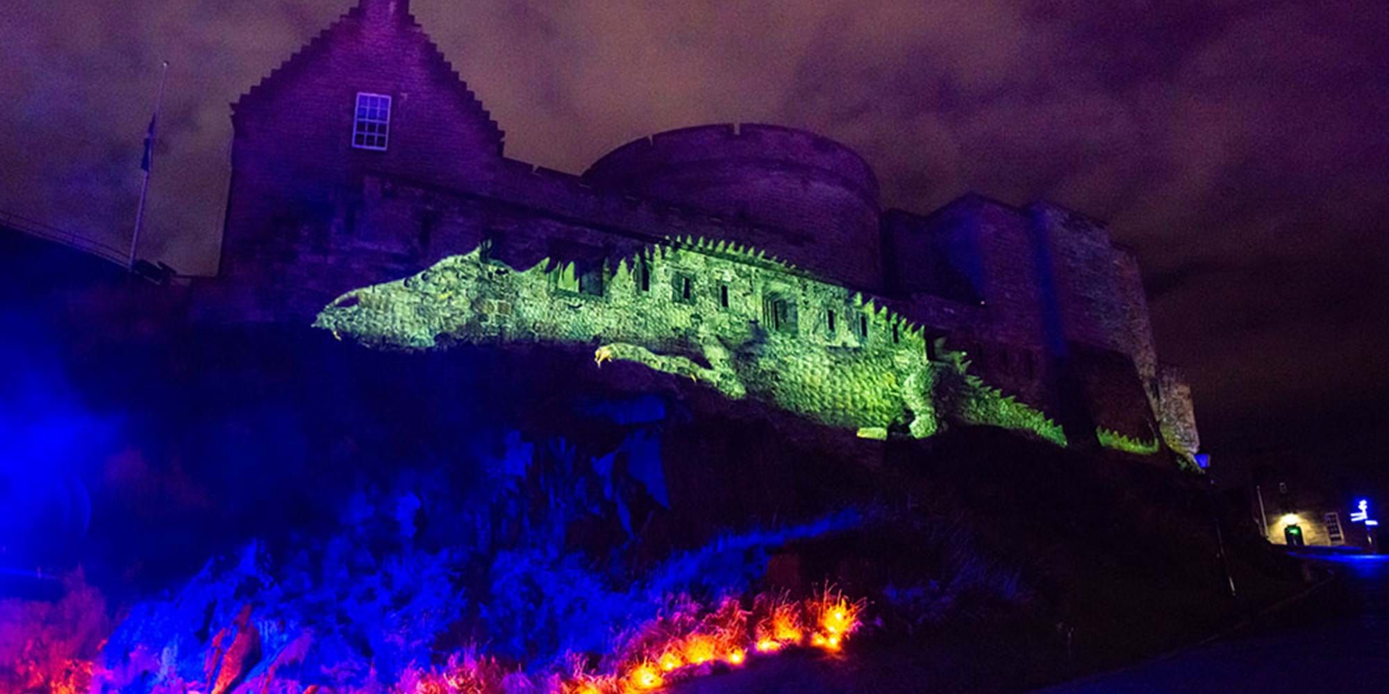 Castle with light projected in colour onto the castle walls